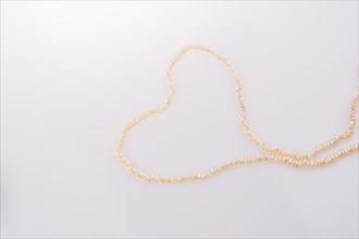 Pearl necklace is placed on white background