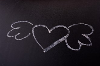 Heart shaped drawing with wings on blackboard