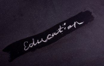 Hand written word EDUCATION with white chalk on black board