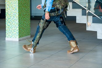Mechanical military exoskeleton to help unrecognizable soldiers and military personnel walking. Camouflage exoskeleton for futuristic high security
