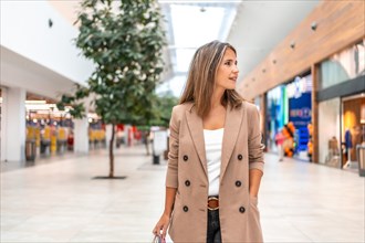 Mature elegant woman walking relaxed along the corridor of a shopping mall