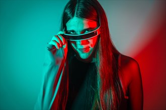 Futuristic studio portrait with neon lights of a sensual transgender person wearing augmented reality googles
