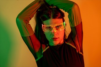 Futuristic studio portrait with neon lights of a sensual transgender person in futuristic neon space using augmented reality goggles