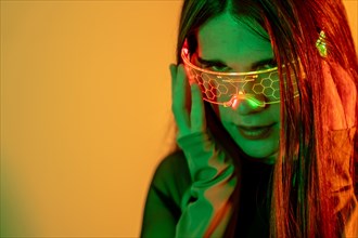 Futuristic studio portrait with neon lights of the eye contact of a transgender futuristic person using smart goggles
