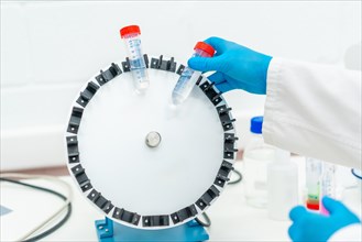 Top view of a scientist placing samples in centrifuge machine