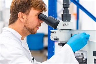 Close-up side view of a doctor using microscope during research in laboratory