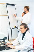 Vertical photo of Scientist working in a cancer research laboratory using computer and writing on a white board