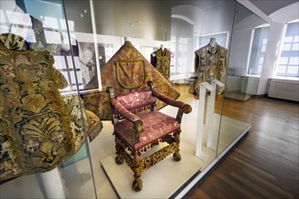 Liturgical vestments and richly carved upholstered chair in the monastery museum