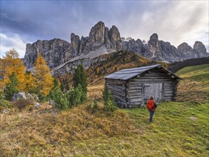 Hiker in front of hut and Sella Group