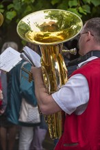 Musician holds his tuba and sheet of music ready to play