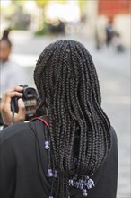 Young girl with black braids holding a camera