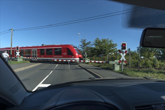 View from a car of the passing railway at a level crossing with barriers