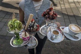 Waitress brings ice cream and drinks to a table
