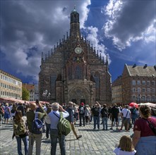 Tourists watch the so-called Maennleinlaufen of the art clock on the main market square since 1509
