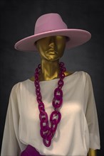 Mannequin with a hat and a fashionable necklace in a fashion shop