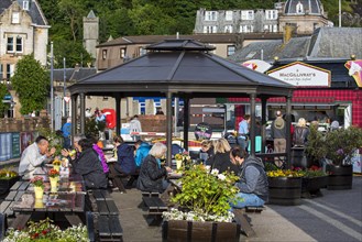 Tourists eating seafood at fish and chips stand in the city Oban