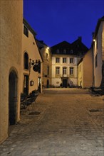 Cobbled inner court inside the Bourglinster Castle illuminated at night