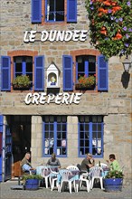 Tourists on terrace eating crepes at creperie in Paimpol