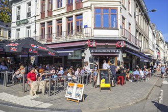 Tourists enjoying Belgian beer on pavement cafe in summer in the city Spa