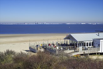 Skyline of the city Vlissingen and beach restaurant pavilion near Breskens along the Western Scheldt
