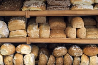 Shelves with loaves of fresh baked bread on display in bakery