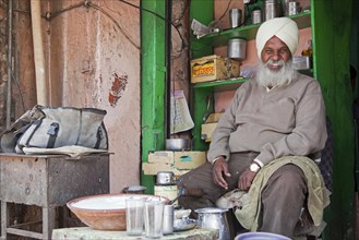 Sikh shopkeeper wearing turban selling lassi