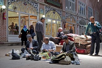 Men repairing carpets in the old historic bazaar of the city Tabriz