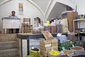 Seller selling spices in shop in the old historic bazaar of the city Tabriz