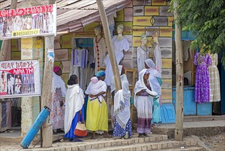 Local black women in shopping street in front of clothes shops in the town Axum