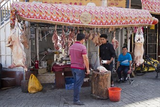 Uyghur street butcher selling pork's meat at butcher's shop