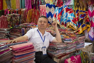 Uyghur vendor selling colourful cloth in fabric store