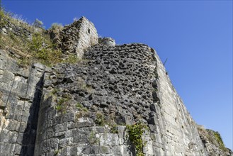 Thick stone wall of medieval castle showing two types of masonry