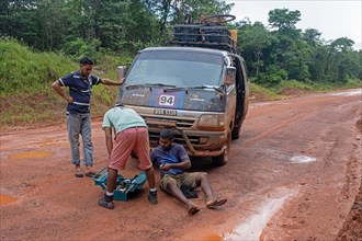 Driver repairing broken down minibus in the rain forest along the Linden-Lethem dirt road linking Lethem and Georgetown