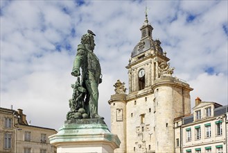 Statue of Victor Guy Duperre in front of the medieval clock tower in La Rochelle