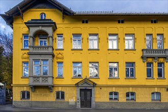 Yellow facade with bay window and balcony