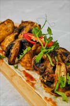Grilled spicy mushrooms on wooden serving board