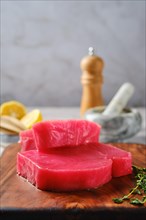 Closeup view of raw ahi tuna steak on cutting board with spice