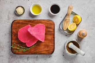 Top view of raw ahi tuna steak on cutting board with spice