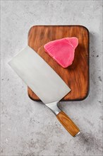 Top view of piece of ahi tuna steak with cleaver