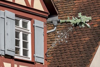 Detail of the half-timbered house with a window and dragon-shaped gutter