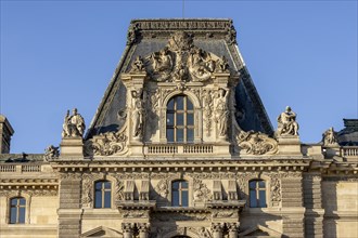 Detail of the opulent Louvre Museum building with sculptures on top