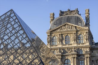 Detail of the Louvre Museum building with reflection on the glass pyramid