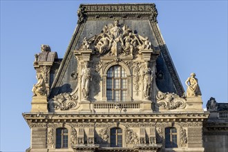 Detail of the opulent Louvre Museum building with sculptures on top