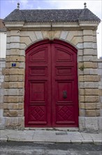 Antique red door on stone walls