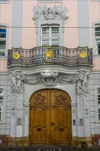 Luxurious entrance door with balcony and figures on the facade