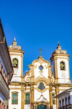 Front of historic baroque style church and surrounding colonial houses in the city of Ouro Preto in Minas Gerais