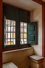 Old window inside a historic baroque church with a view of the colonial houses in the city of Ouro Pretro