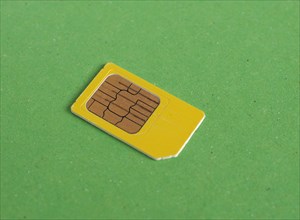 Phone sim card over green with copy space