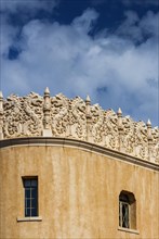 Clay plaster facade with stucco decoration