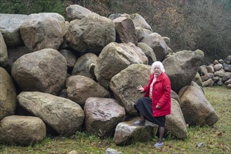 Woman stand at a stone storage in the nature in Fyledalen